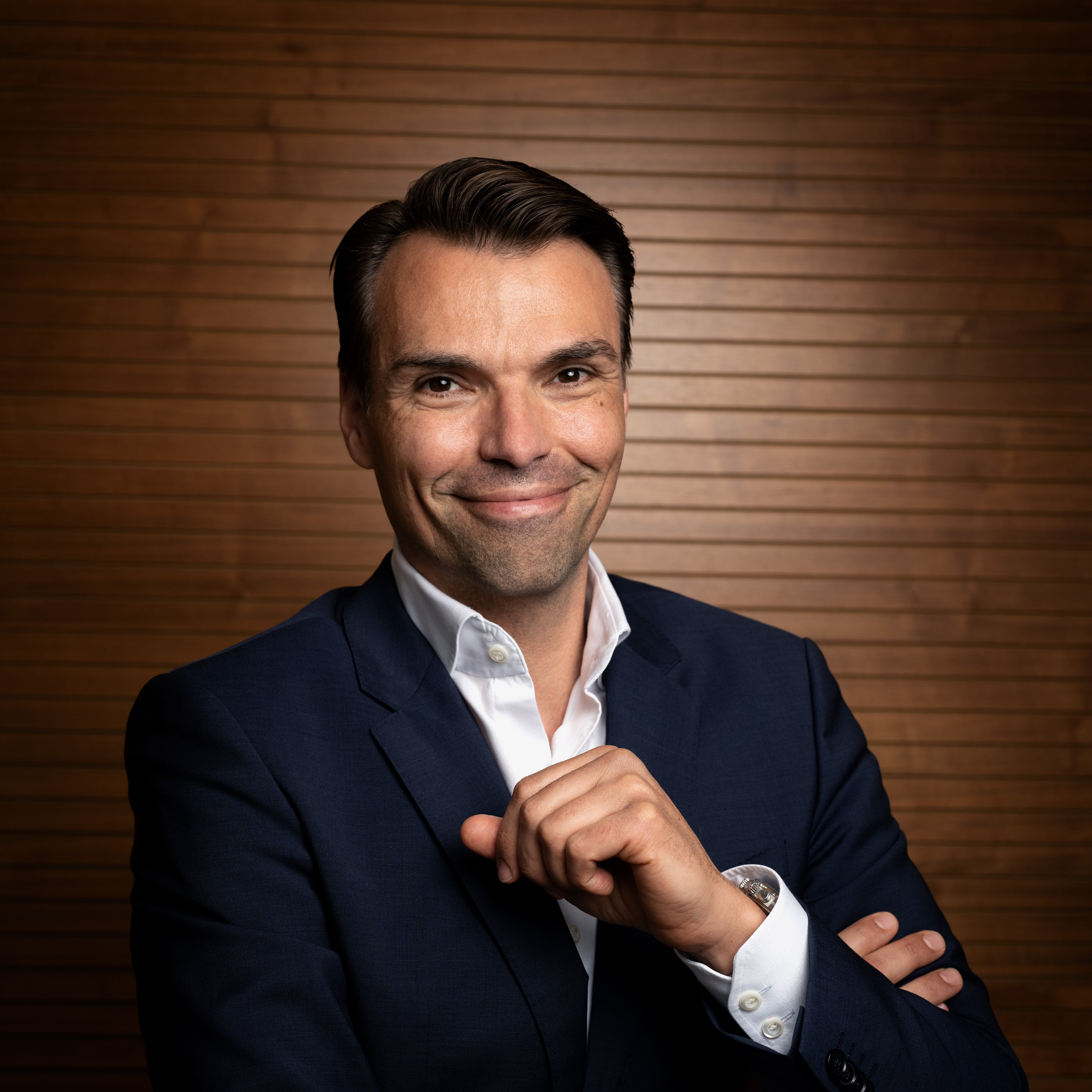 A man in a suit smiling, representing CANCOM Austria's press information section.