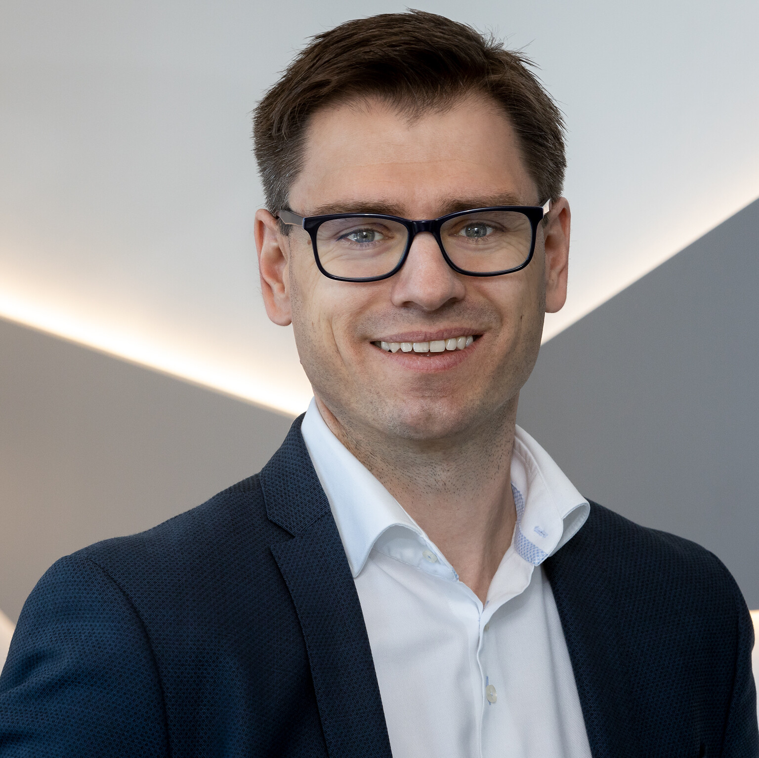 A man wearing glasses and a suit, representing CANCOM Austria in a press photo.